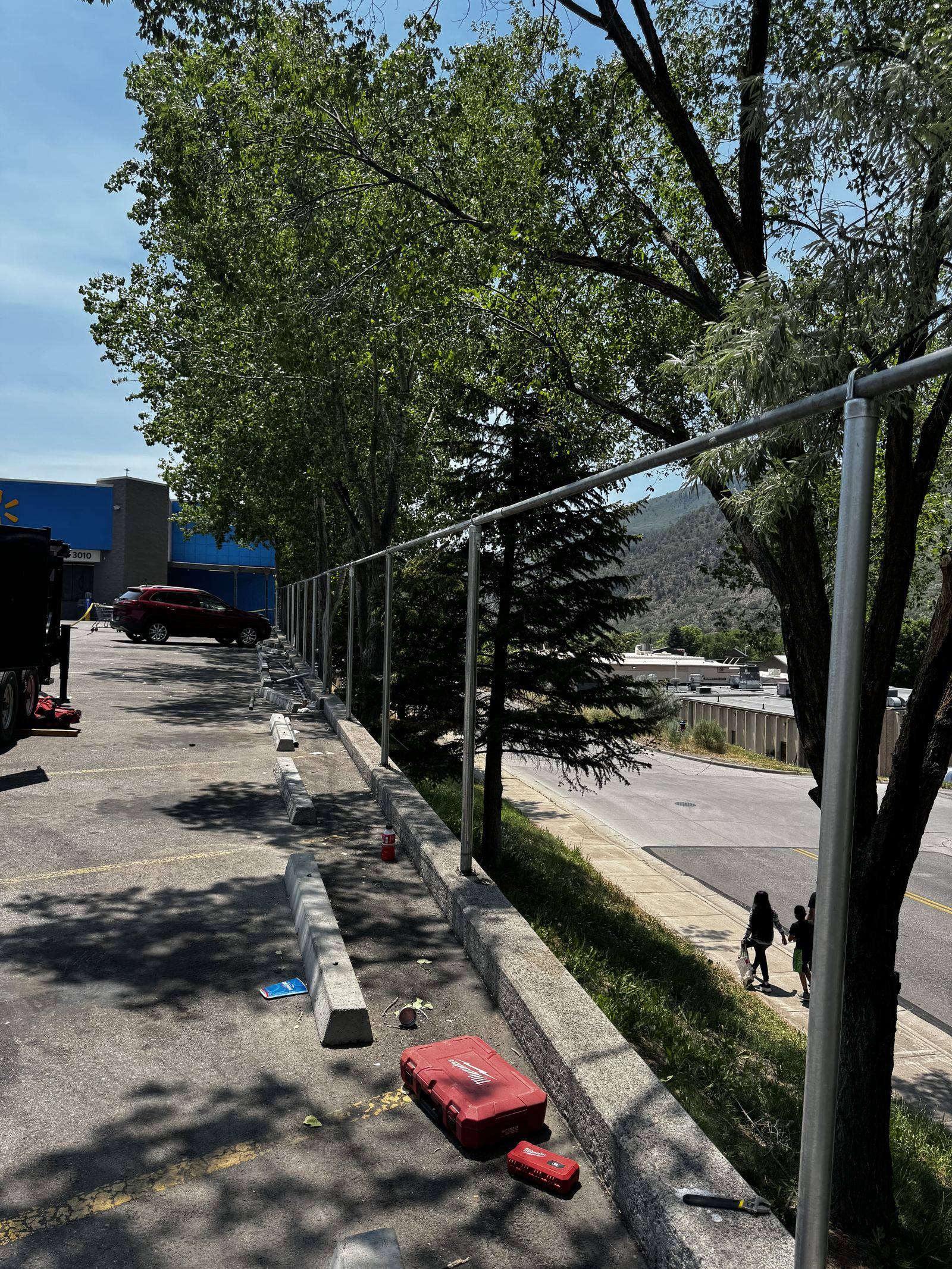 Dedicated Solutions & More crew setting a chain-link fence line at a retail site